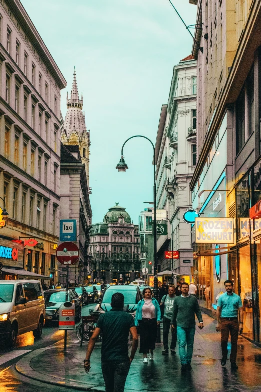 a view of people walking down a city street