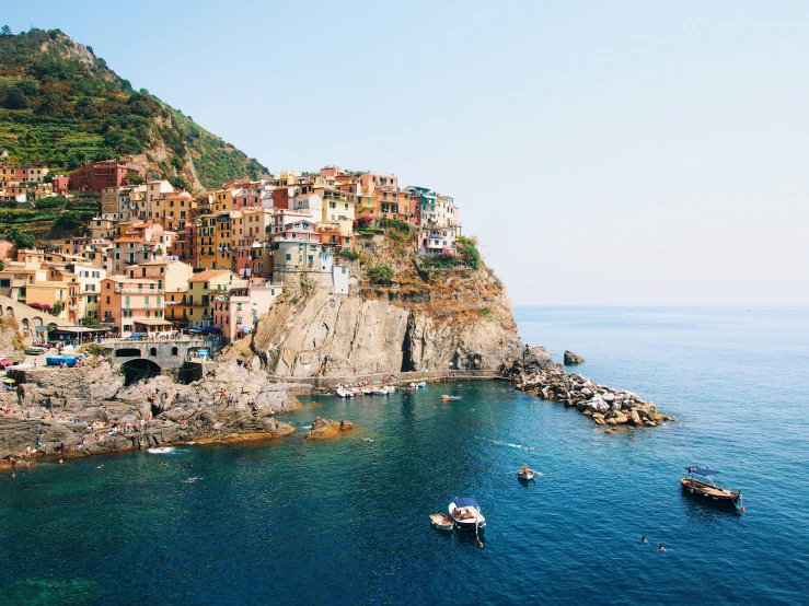 a village sits on a cliff above the ocean