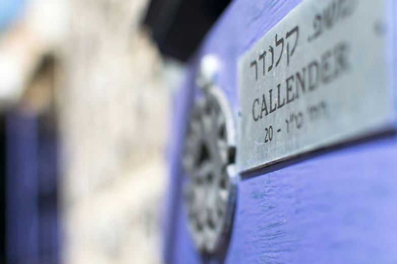 the front of a blue car with a white sign in hebrew