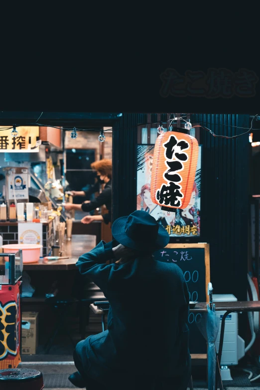 a man is sitting on the sidewalk in front of a store