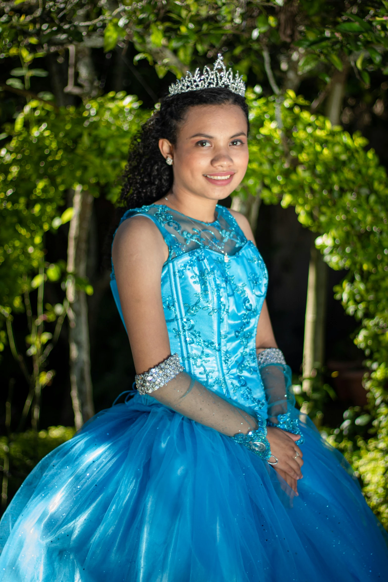 a girl in a blue dress standing on a park bench