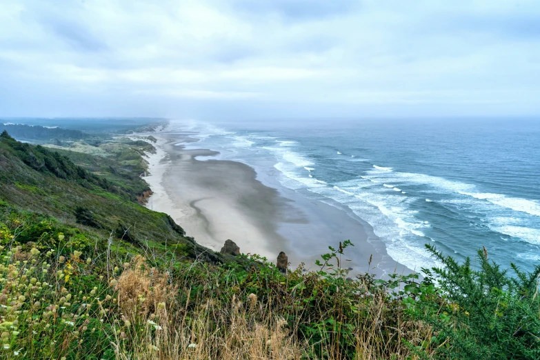 the ocean and sand line of a mountain side