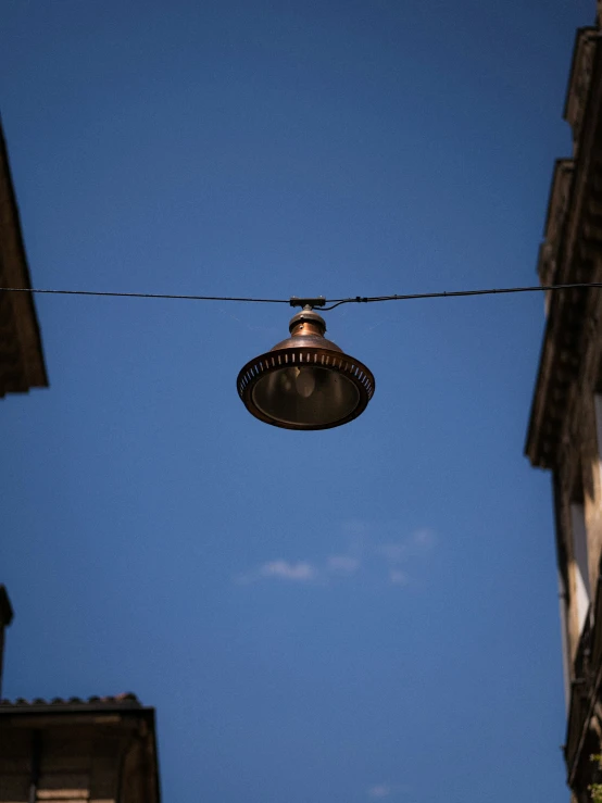 a street light suspended over an alley with buildings in the background