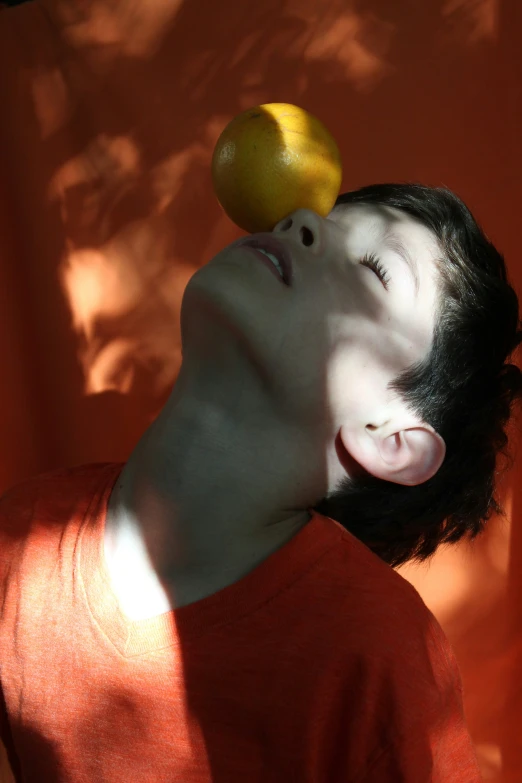 an asian man is looking up to a yellow object in his ear