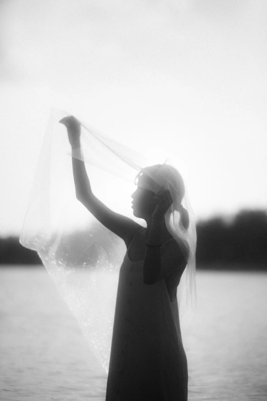 woman standing on beach with head in hands