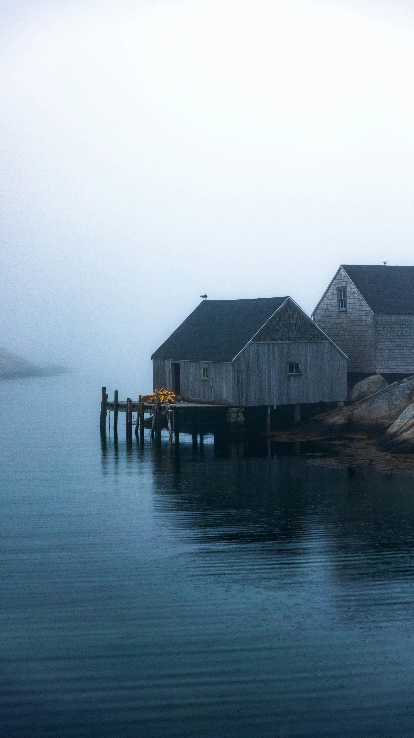 houses on a dock in the water in fog