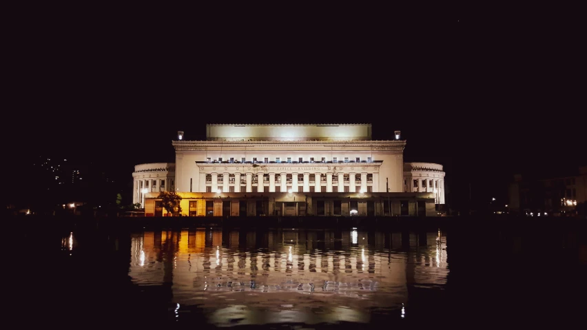 an old building in the dark reflecting in the water