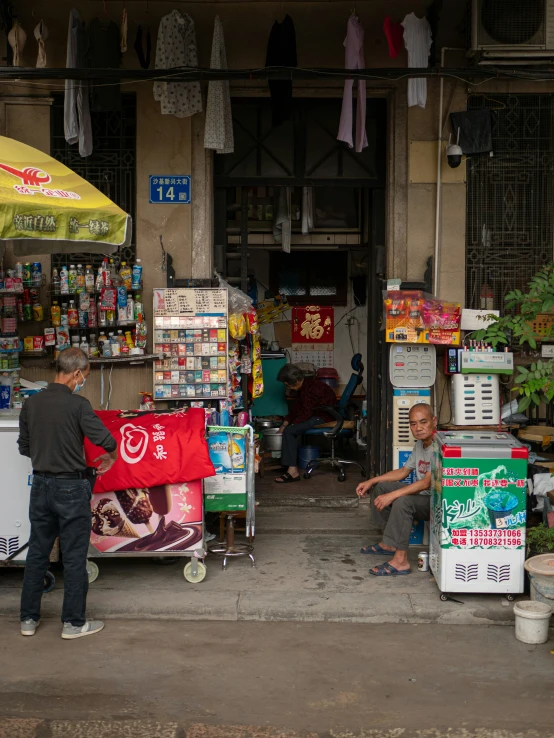 some people in front of a store selling umbrellas