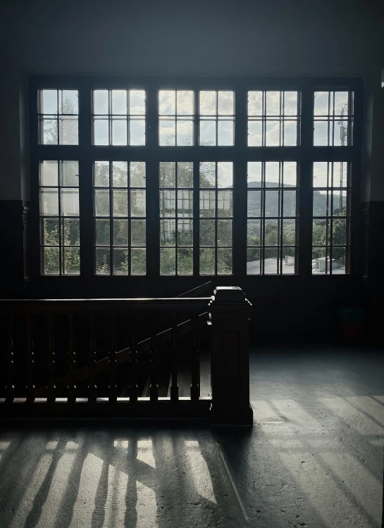 a bench and large window in an old house