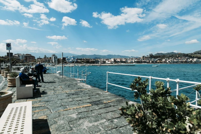 a pier with people on the dock and in the water