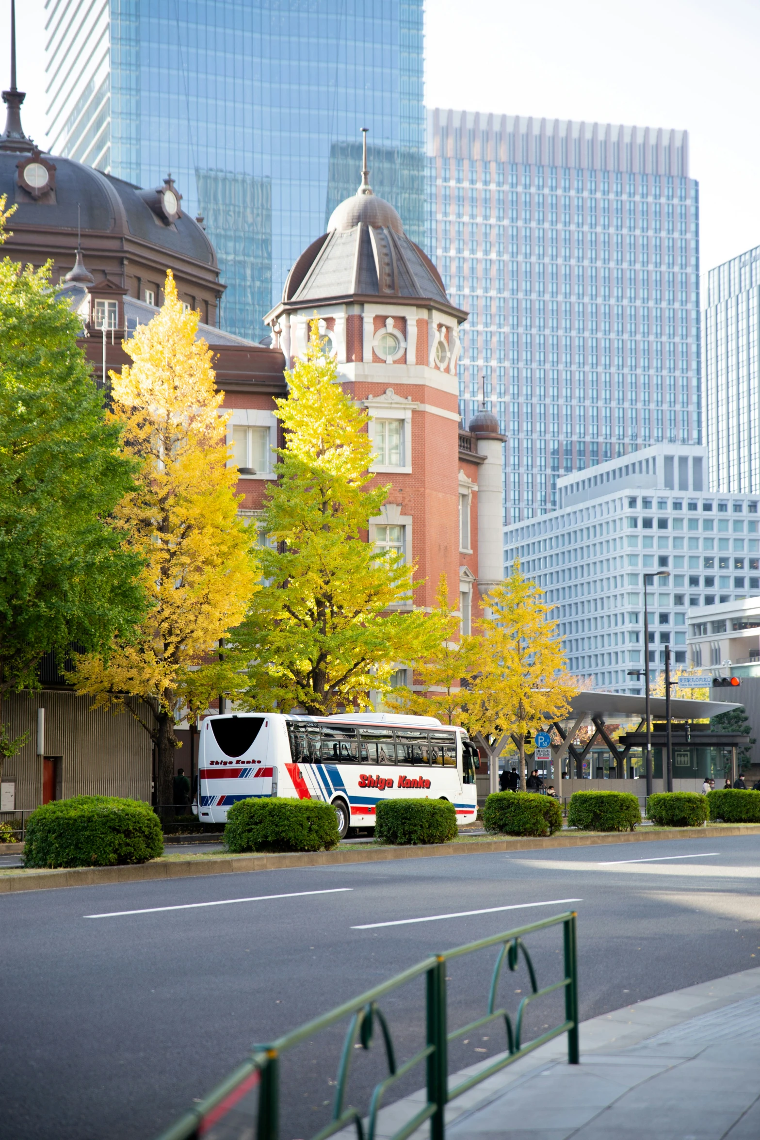 two buses parked in front of some tall buildings