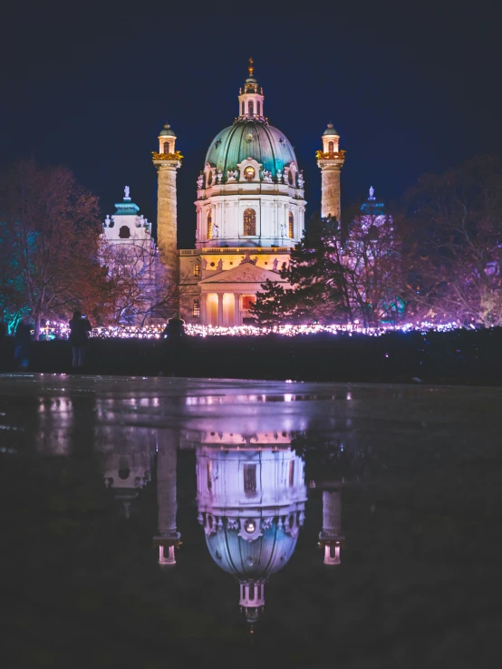 the dome of a building reflects in a lake