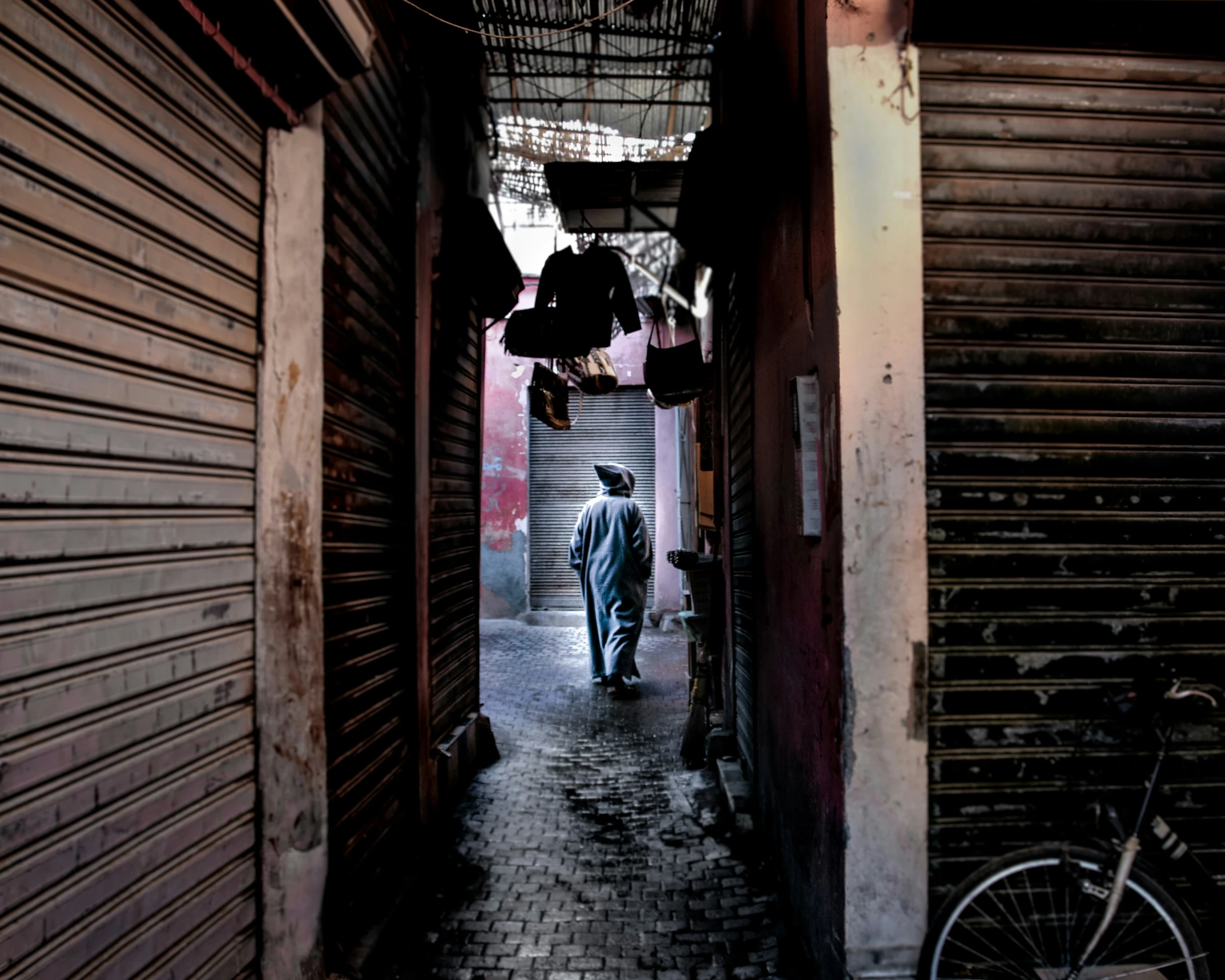 an alleyway with a person walking down the street