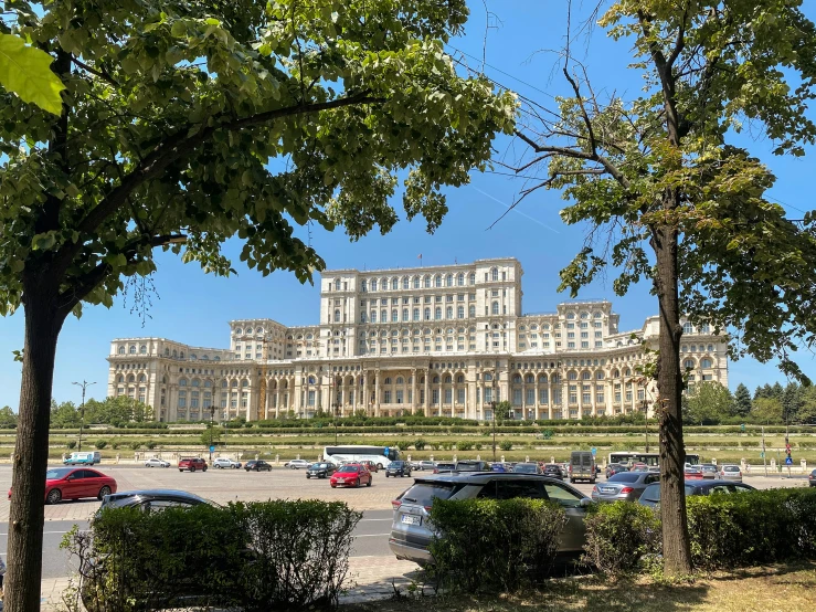 several cars parked in front of a very large building