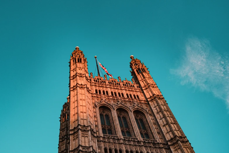 the top part of the tower is lit up against the blue sky