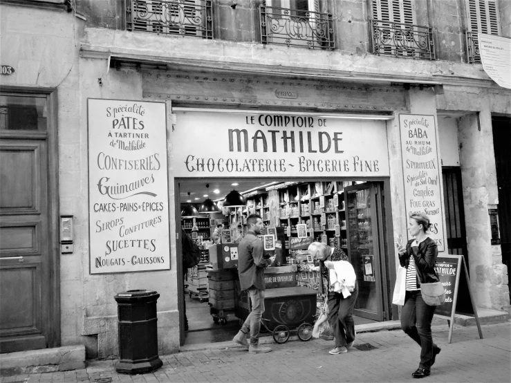 black and white pograph of a building with people walking by