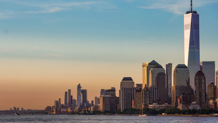 city skyline with tall buildings and a boat in the ocean