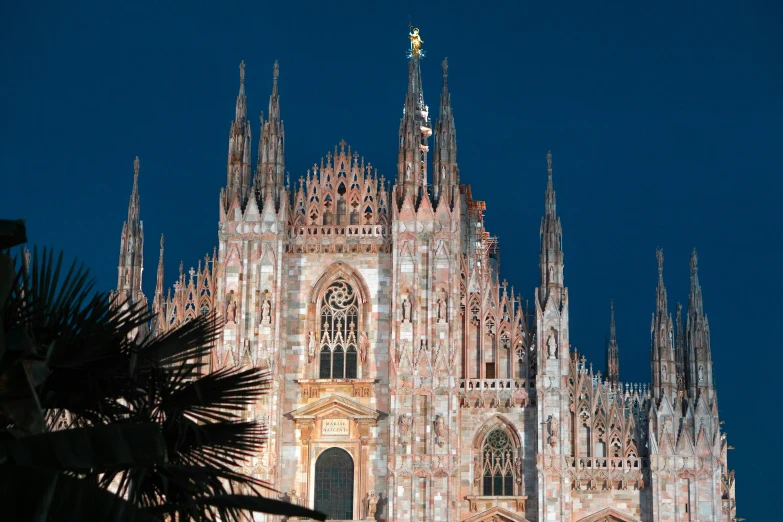 a cathedral with a clock at the top is lit up