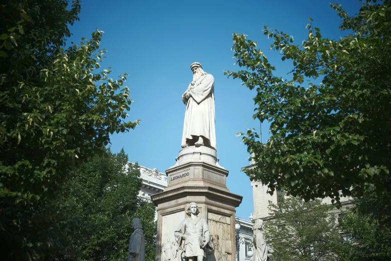 a statue is in the center of a cemetery with tall buildings around it