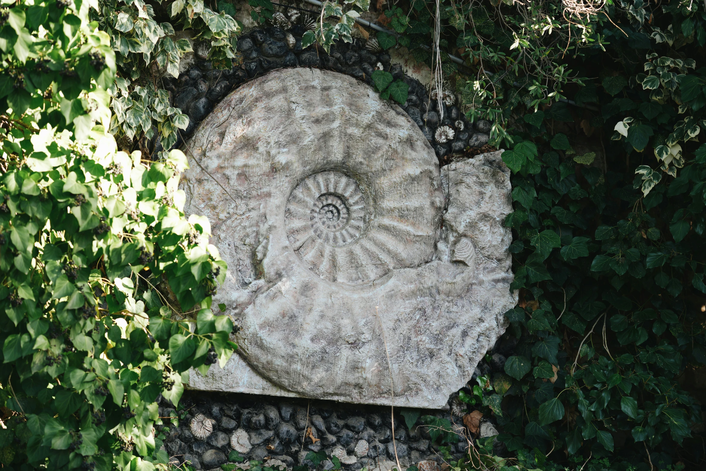 a white rock surrounded by trees and foliage