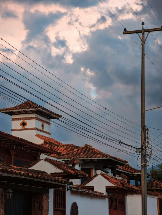 a street with many wires hanging from it and a clock tower next to it