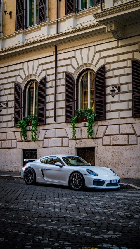 an exotic vehicle parked on a cobblestone street in front of a building