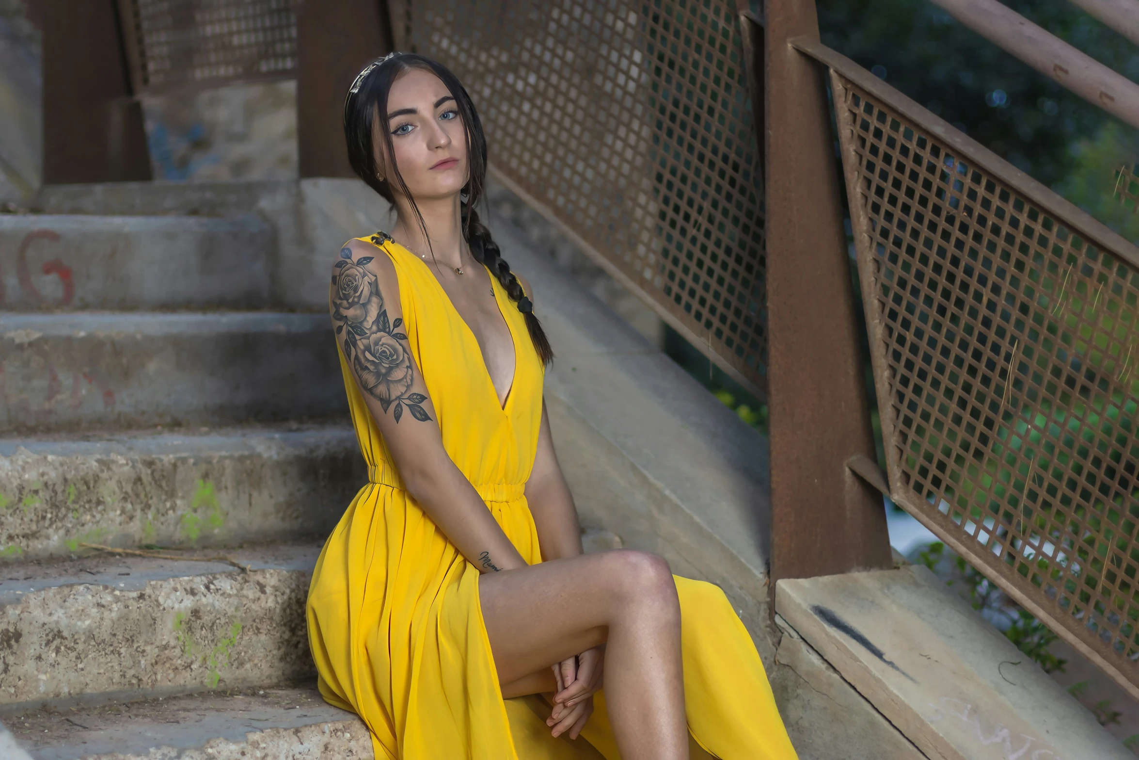 a woman sitting on some steps wearing a yellow dress