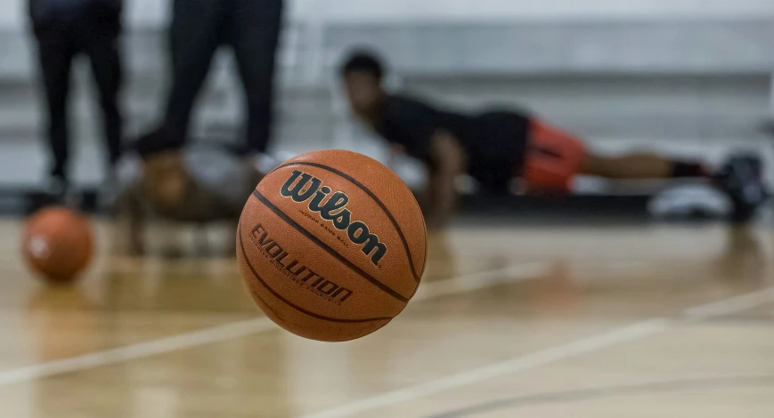 a basketball is sitting on the floor of a gym