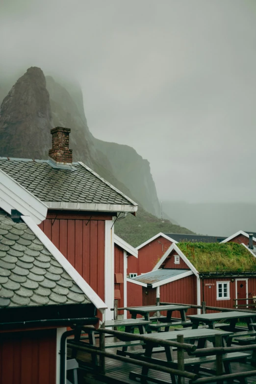 some red houses are next to mountains in the mist