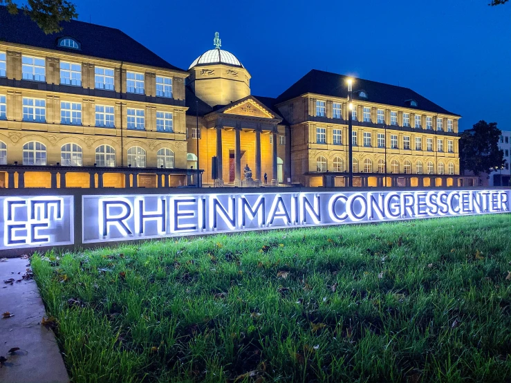 the illuminated sign for the conference is visible in front of a building