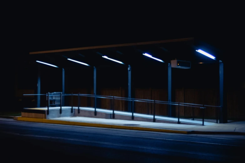 the empty bus stop is lit up at night