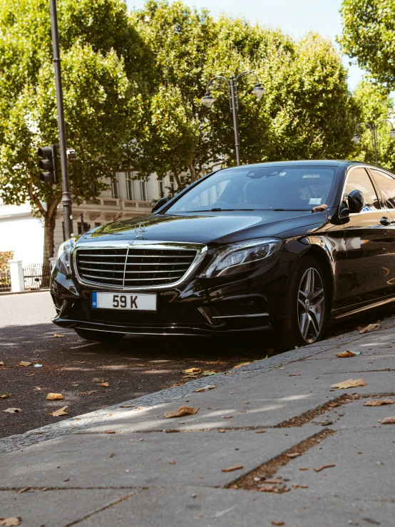 a black mercedes parked on the side of a road
