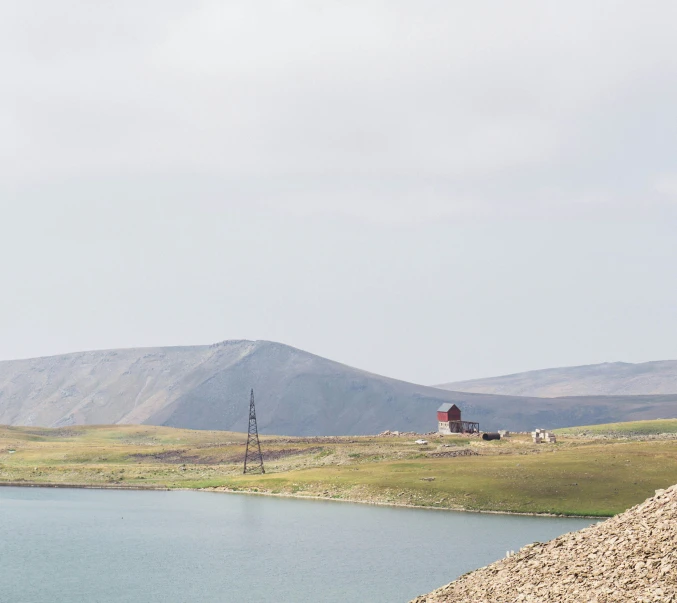 a lake and mountain in the distance with a light house in the background