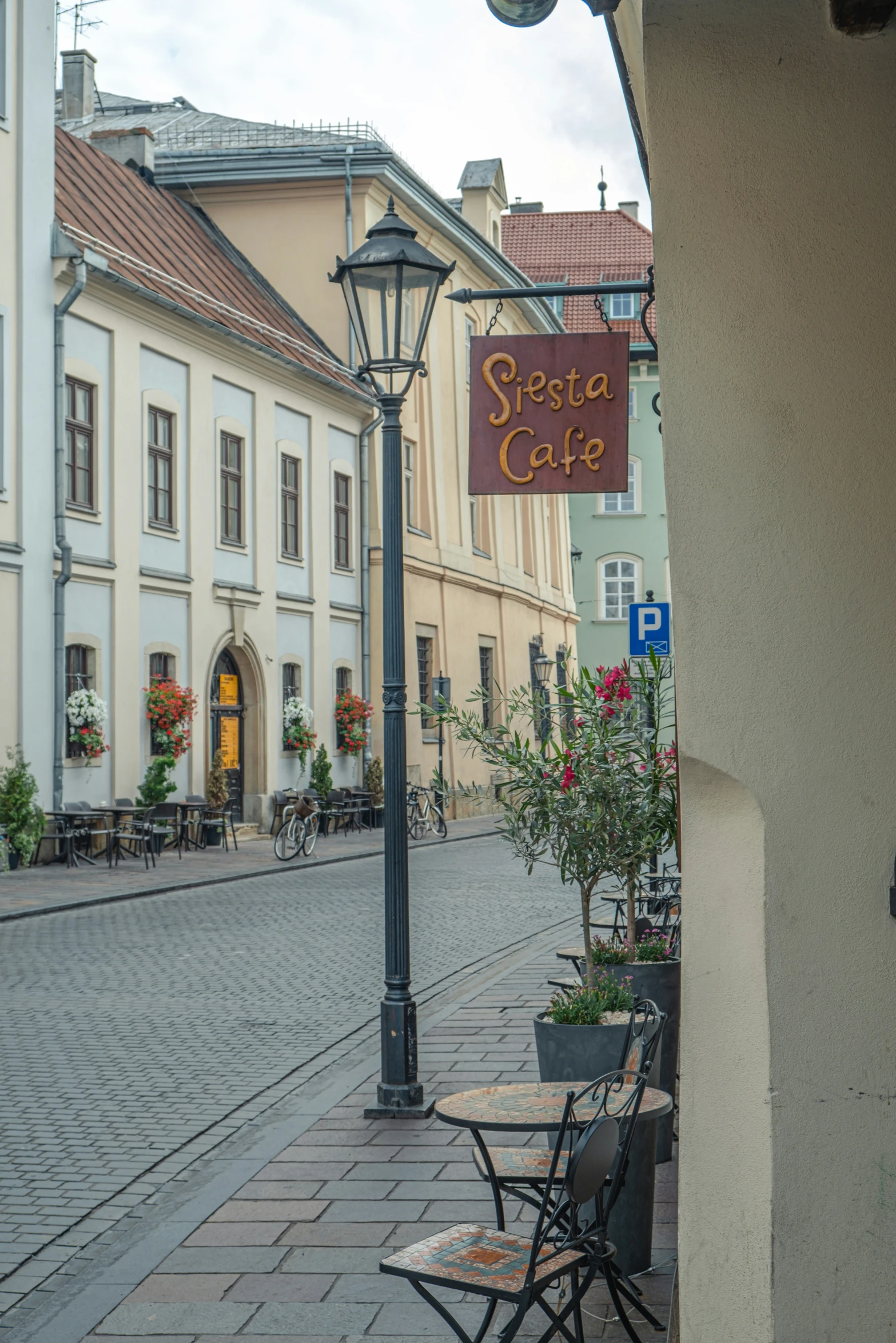 an empty street has some benches with a cafe sign