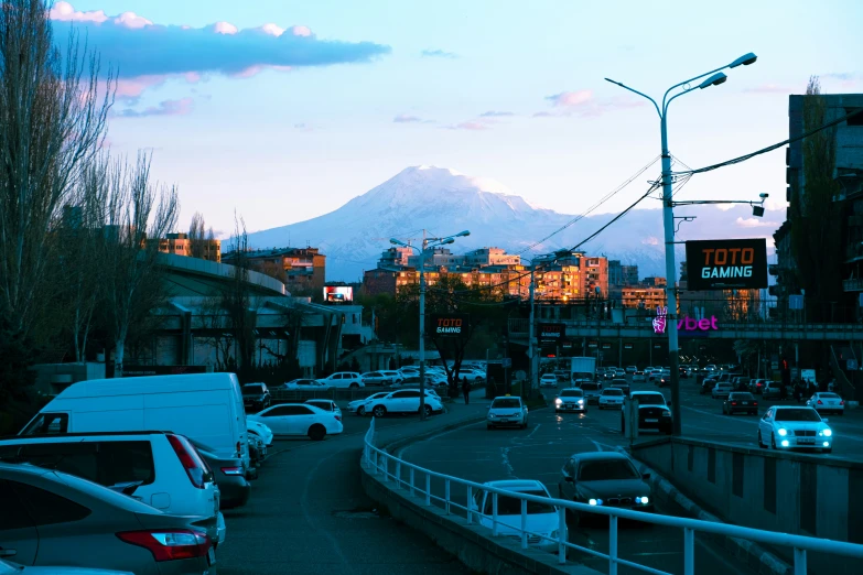 a city street with cars and mountains in the background