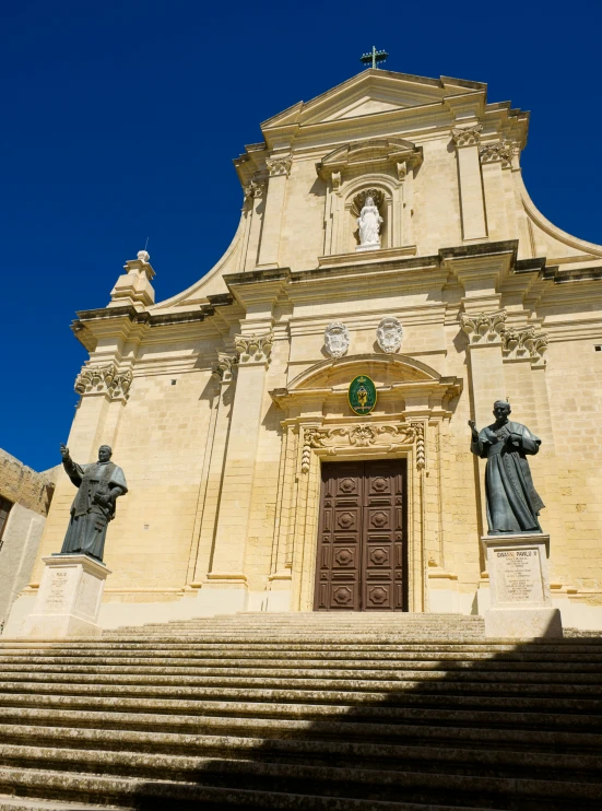 some statues sitting in front of a large church