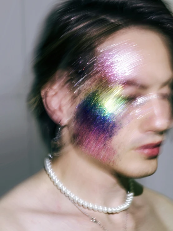 a man with a rainbow face painted with soing