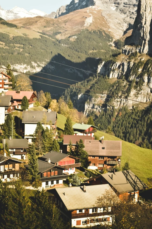 a city is surrounded by mountains and evergreen trees