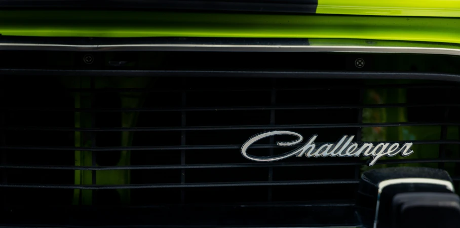 a green car with the name challenger spelled in cursive ink