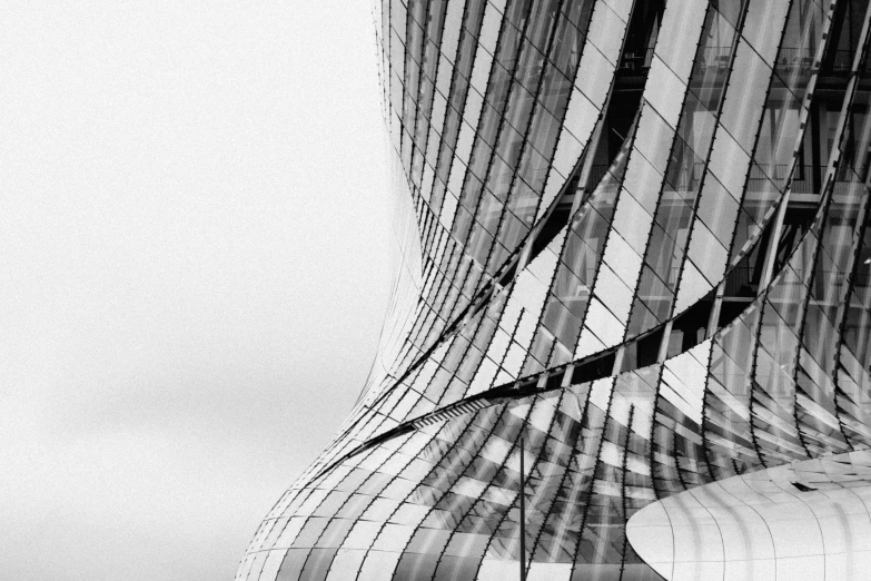 this black and white po shows the wavy lines of a building's glass facade