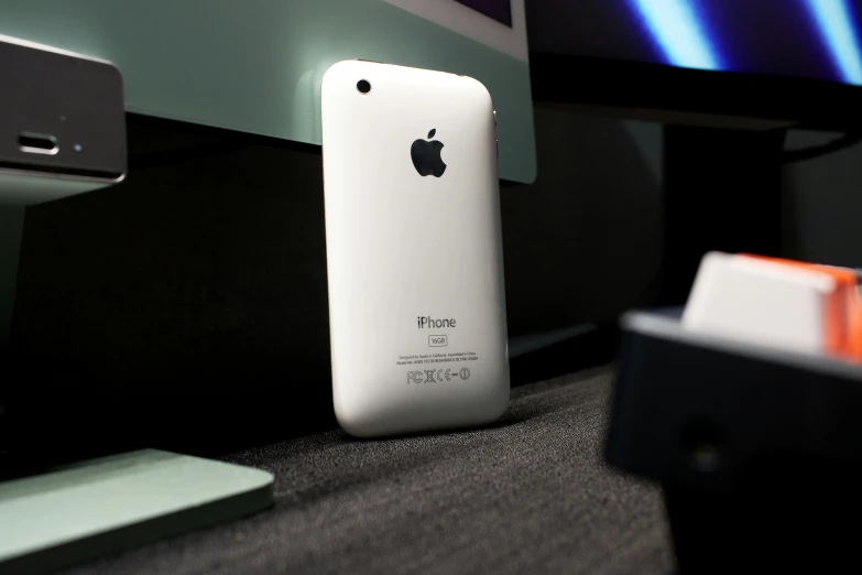 an apple phone sits next to an electronic device