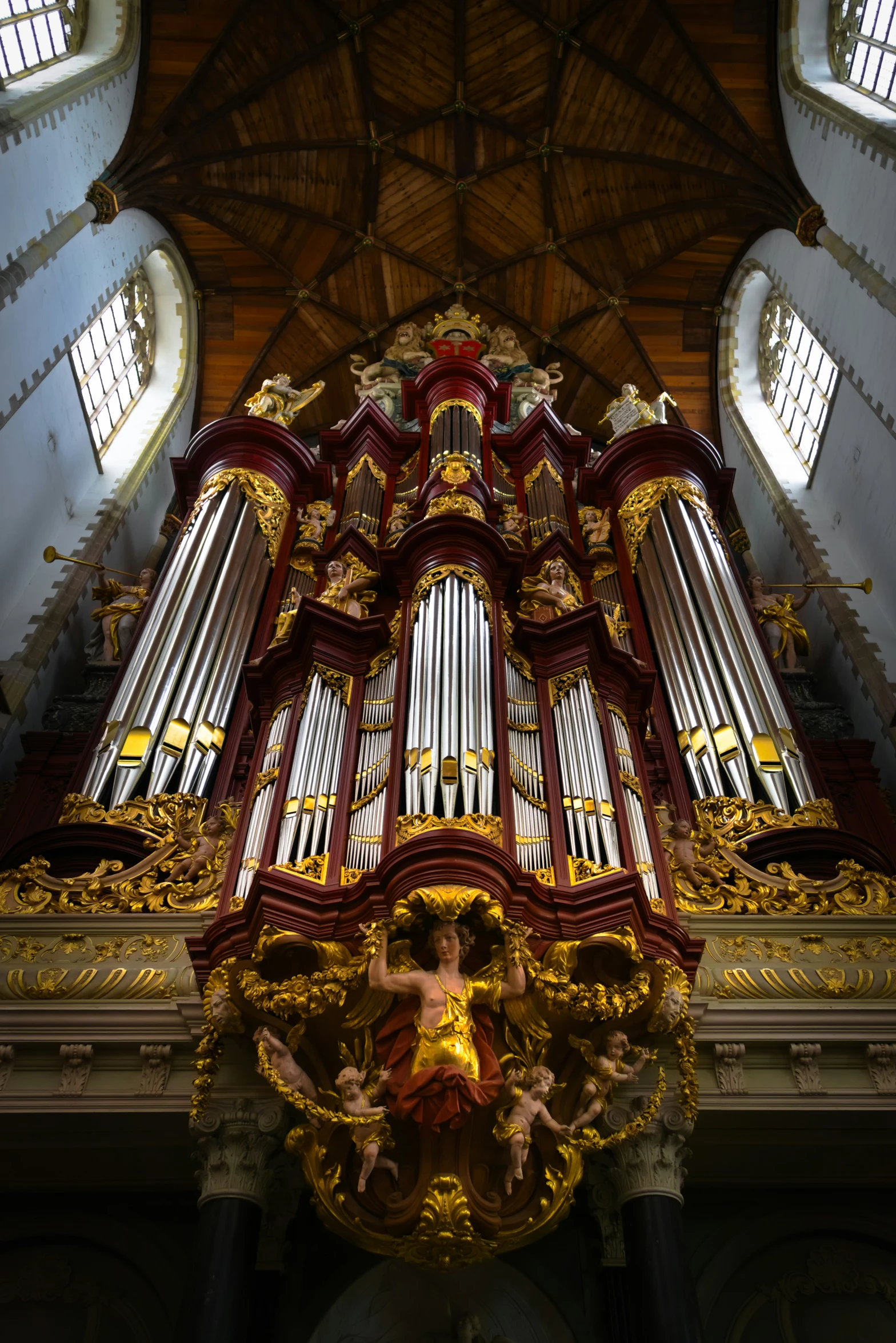 an elaborately detailed pipe organ in the back of a cathedral