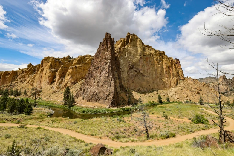 the landscape features many tall rocks and a dirt path