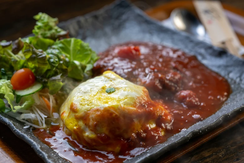 a picture of some meatball pasta with tomato sauce and lettuce