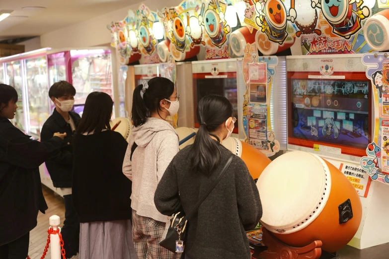 people looking at an interactive video game in an amut mall