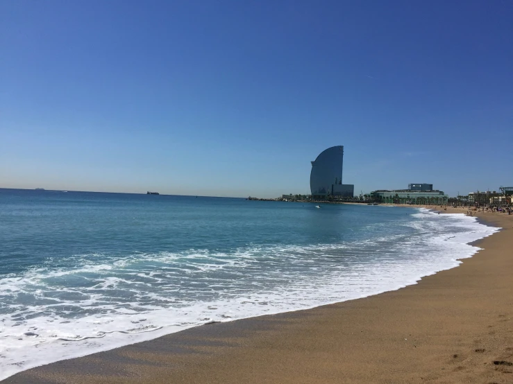 a wave comes in from the water as it moves along a beach