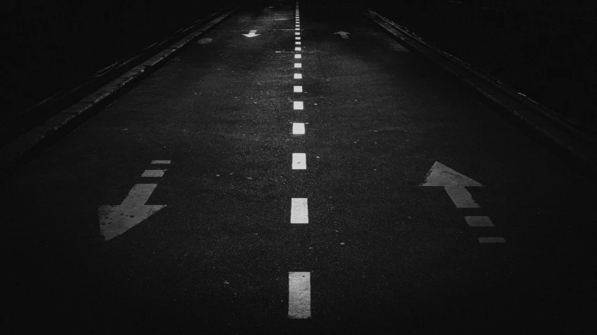 the roadway of an empty road at night