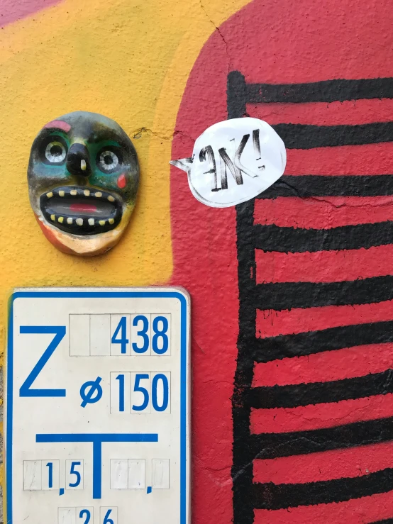 a painted wall has a face and clock
