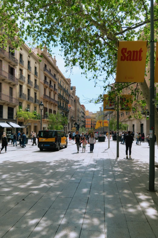 people are walking along the sidewalk in the city