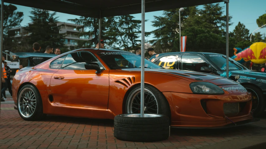 an orange sports car parked near other vehicles